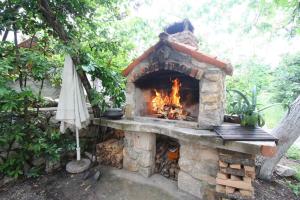 a stone fireplace with an umbrella next to it at Holiday home in Silo/Insel Krk 26695 in Šilo