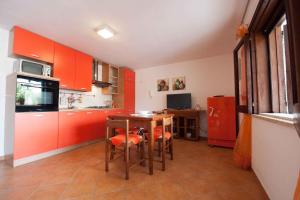 a kitchen with orange cabinets and a table and a refrigerator at Apartment Siracusa/Insel Sizilien 23389 in Ognina