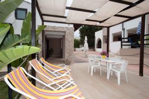 a patio with a white table and chairs and a table and chairsearcher at Two-Bedroom Apartment in Siracusa II in Ognina