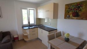 a small kitchen with a table and a dining room at Apartment in Malinska/Insel Krk 13118 in Sveti Vid-Miholjice
