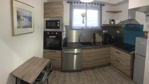 a kitchen with a sink and a stove top oven at Appartement à 300m du centre et des plages in Collioure