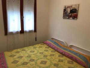 a bedroom with a bed with a quilt on it at Apartment in Rosolina Mare 25092 in Rosolina Mare