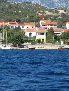 a large body of water with houses in the background at Apartment in Barbat/Insel Rab 16248 in Barbat na Rabu