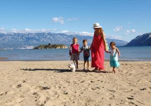 a woman and three children standing on a beach with a dog at Apartment in Barbat/Insel Rab 16248 in Barbat na Rabu