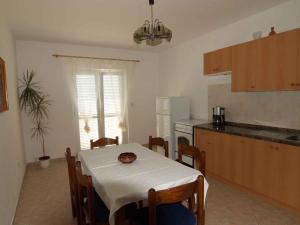 a kitchen with a table with a white table cloth on it at Apartment in Rab/Insel Rab 16489 in Palit