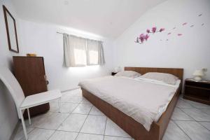 a bedroom with a bed and a chair at Apartment Crikvenica 16 in Crikvenica
