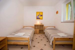 2 camas individuales en una habitación con ventana en Two-Bedroom Apartment in Porec V, en Poreč