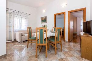 a kitchen and dining room with a table and chairs at Apartment Rogoznica/Sibenik Riviera 7186 in Zaglavice