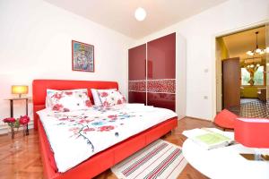 ein Schlafzimmer mit einem roten Bett mit einem roten Kopfteil in der Unterkunft Holiday home Poljana - Insel Ugljan 7467 in Poljana + 8 Fotos