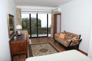a room with a bed and a chair and a window at Casa de Santo Antonio in Mortágua +27 photos