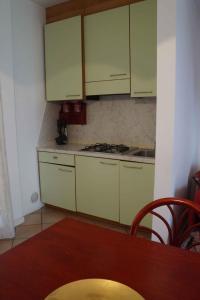 uma cozinha com armários brancos e uma mesa de madeira em Apartment in Rosolina Mare 29520 em Rosapineta