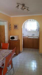 a kitchen with a table and a sink and a microwave at Holiday home Balatonlelle - Balaton 19117 in Balatonlelle