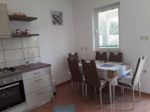 une cuisine avec une table et des chaises dans l'établissement Apartment in Lopar with Two-Bedrooms 3, à Lopar