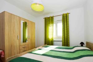 ein Schlafzimmer mit einem grünen und weißen Bett und einem Fenster in der Unterkunft Apartment in Pula with Two-Bedrooms 3 in Pula