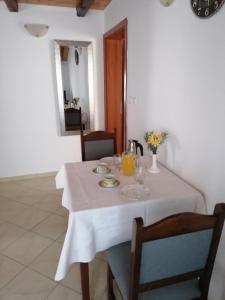 a white table with a white table cloth on it at One-Bedroom Apartment in Baric Draga II in Barić Draga