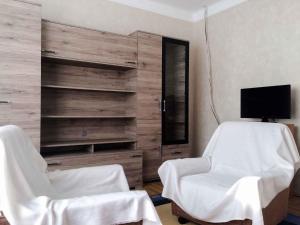 a room with two white chairs and a television at Holiday home in Siofok - Balaton 19801 in Siófok