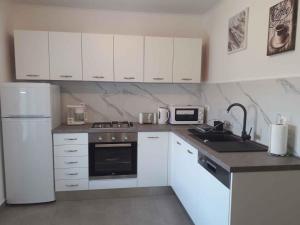 a kitchen with white cabinets and a white refrigerator at Apartment in Lopar with Two-Bedrooms 2 in Lopar