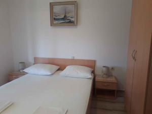 a bed with two pillows and a picture on the wall at Apartment in Lopar with Two-Bedrooms 2 in Lopar