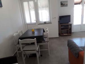 a dining room with a table and chairs and a television at Apartment in Lopar with Two-Bedrooms 2 in Lopar