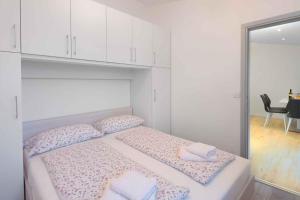 a bedroom with a bed with two pillows and a mirror at Apartment in Rabac 16817 in Rabac