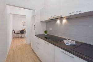 a kitchen with white cabinets and a sink and a table at Apartment in Rabac 16817 in Rabac