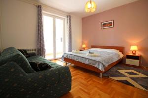 a bedroom with a bed and a couch and a window at Apartments in Porec/Istrien 9899 in Poreč