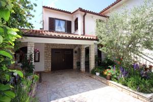 a house with a door and a courtyard with flowers at Apartments in Porec/Istrien 9899 in Poreč