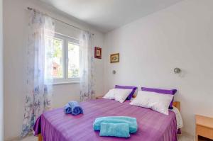 a bedroom with a purple bed with two towels on it at Apartment in Prizba/Insel Korcula 6425 in Prizba