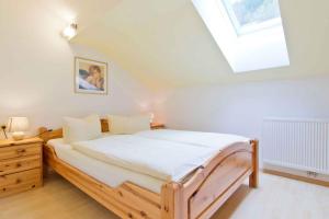 ein Schlafzimmer mit einem Holzbett und einem Dachfenster in der Unterkunft Apartment in Schlitters with Two-Bedrooms 1 in Schlitters