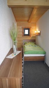 ein kleines Schlafzimmer mit einem Bett und einem Tisch in der Unterkunft Holiday home in Friedland 2712 in Kummerow