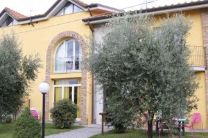 a yellow house with a tree in front of it at Apartment in Lucca/Toskana 23961 in San Cassiano a Moriano