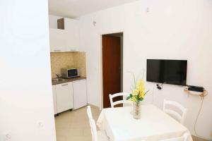 una cocina con una mesa con un jarrón de flores. en Brna, otok Korcula Two-Bedroom Apartment 1 en Brna