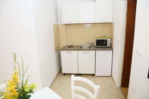 eine kleine Küche mit einer Spüle und einer Mikrowelle in der Unterkunft Brna, otok Korcula Two-Bedroom Apartment 1 in Brna