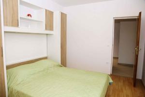a small bedroom with a green bed and a hallway at Brna, otok Korcula Two-Bedroom Apartment 1 in Brna