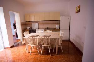 eine Küche mit einem Tisch und Stühlen sowie einem Kühlschrank in der Unterkunft Apartment Brna 2 in Brna