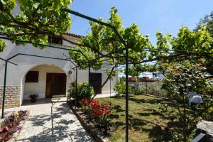 a garden in front of a house with flowers at One-Bedroom Apartment in Stinjan I in Štinjan