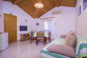 a living room with a bed and a table with chairs at Apartments in Mali Losinj 14985B in Mali Lošinj