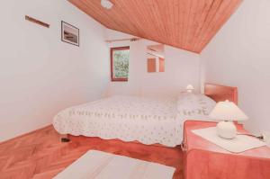 a bedroom with a bed and a table with a lamp at Apartments in Mali Losinj 14985B in Mali Lošinj