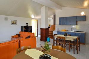 a kitchen and a living room with a couch and a table at Four-Bedroom Apartment in Stinjan I in Štinjan