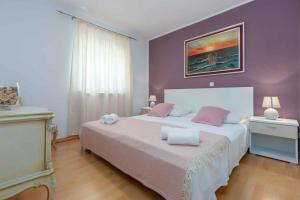 a bedroom with a large bed with purple walls at Holiday home in Kaldanija/Istrien 12040 in Kaldanija