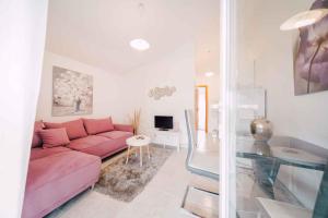 - un salon avec un canapé rose et une table dans l'établissement One-Bedroom Apartment in Ljubac I, à Krneša