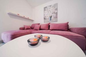 two bowls on a white table in a living room at One-Bedroom Apartment in Ljubac I in Krneša