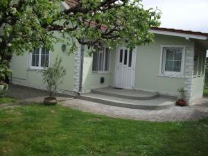 a small green house with a tree in the yard at Holiday home Balatonlelle - Balaton 19117 in Balatonlelle