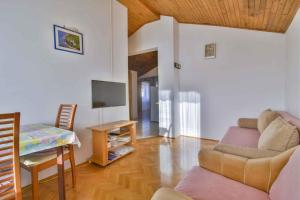 a living room with a couch and a table at Apartments in Mali Losinj 14985C in Mali Lošinj