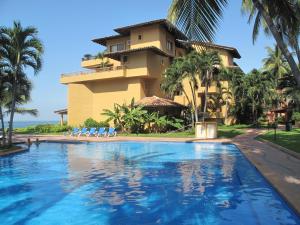 un complejo con piscina frente a un edificio en Villas del Sol en Los Tules, en Puerto Vallarta