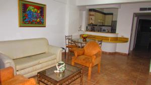 ein Wohnzimmer mit einem Sofa, Stühlen und einem Tisch in der Unterkunft Departamento Carabelas de Colón in Playas