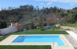 een zwembad in een tuin met een heuvel op de achtergrond bij Casa de Santo Antonio in Freixo