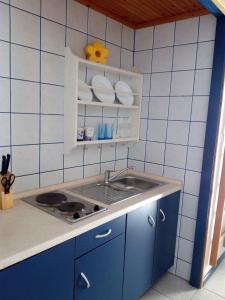 a kitchen with a sink and a blue tiled wall at Vodice Apartment 2 in Vodice