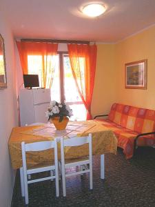 ビビオーネにあるApartments in Bibione 24576のテーブル、椅子、ベッドが備わる客室です。