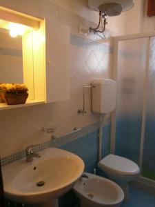 a bathroom with a sink and a toilet and a mirror at Apartment in Bibione 24409 in Bibione